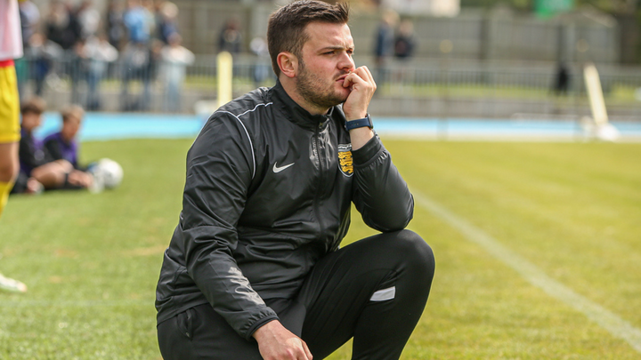 Elliot Powell crouching down pitchsideat the 2023 Muratti